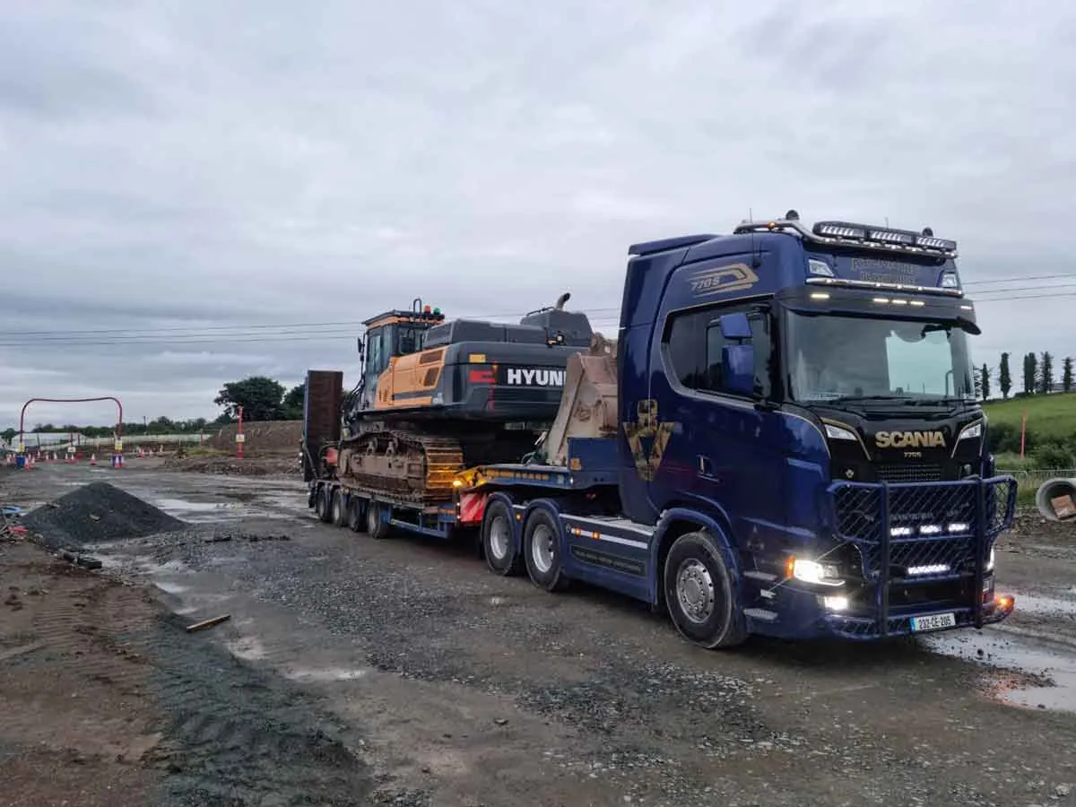 Truck transporting an excavator on a low-loader trailer
